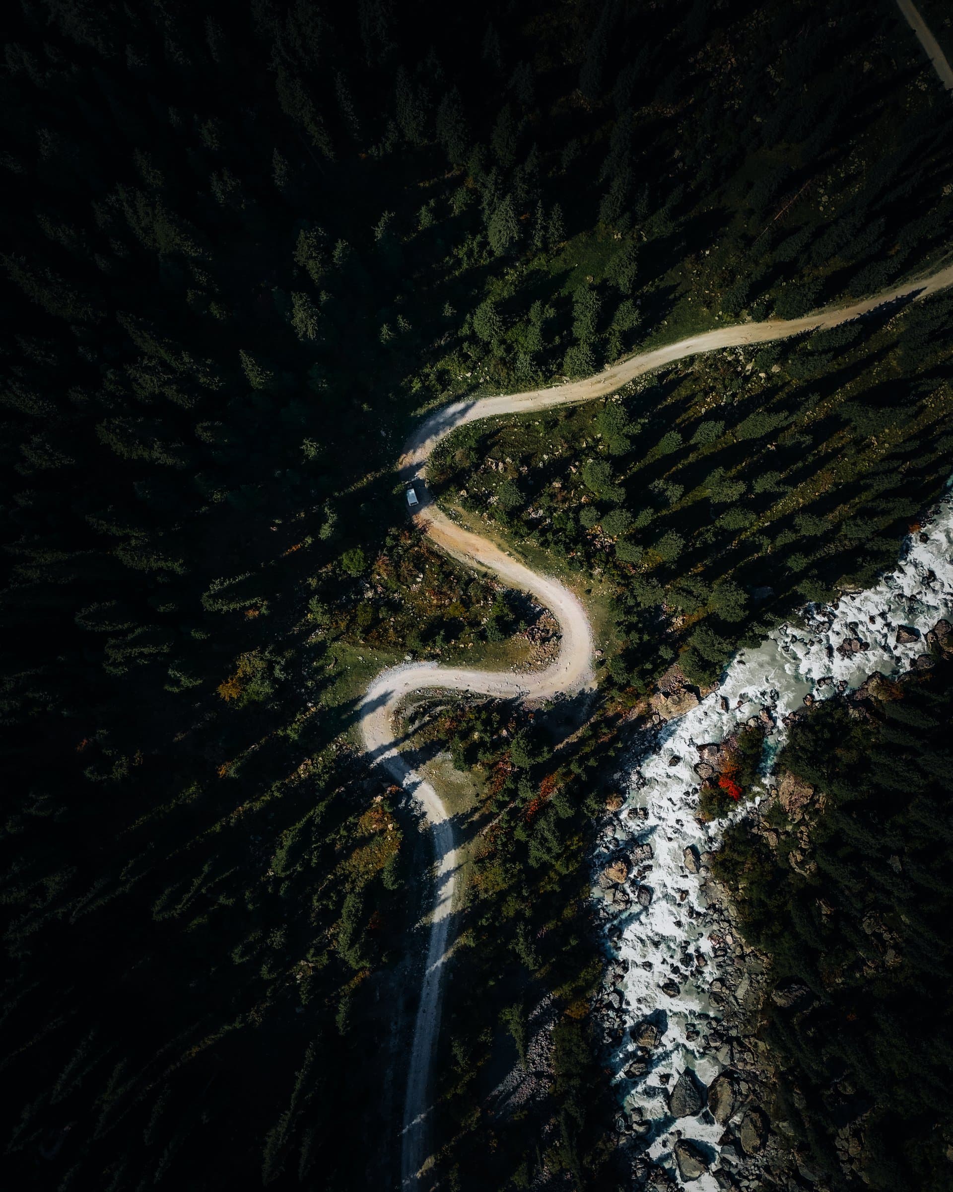 A winding mountain road cutting through forested slopes