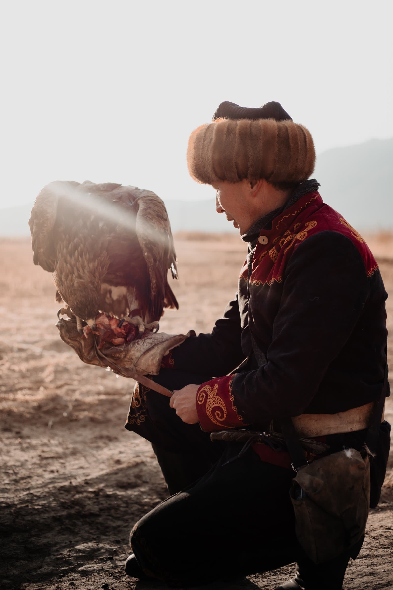 A Kyrgyz eagle hunter in traditional dress with his golden eagle