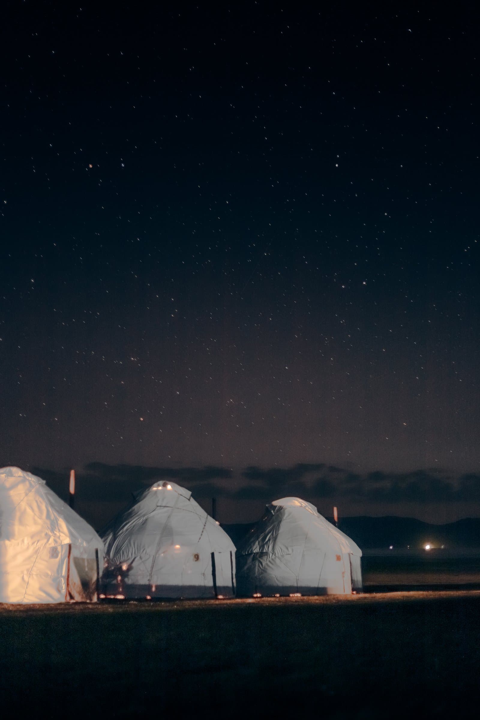 Yurts glowing under a starry night sky on the Kyrgyz steppe